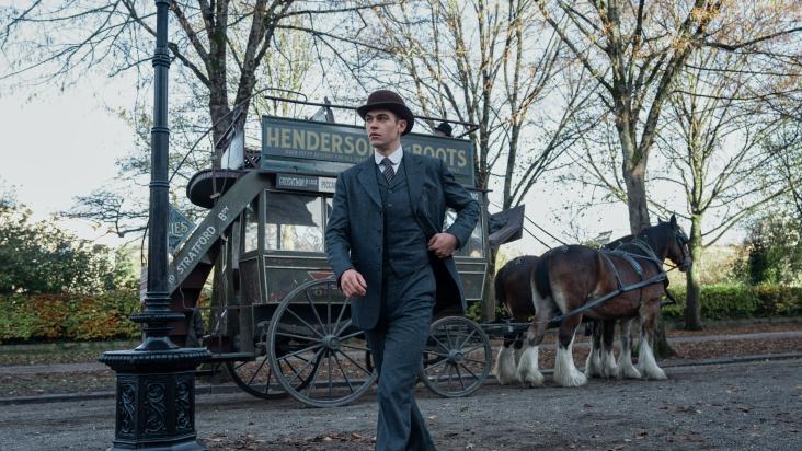 Portread o Mrs Coulter (Ruth Wilson) yn gwisgo cot goch a het goch yn His Dark Materials.